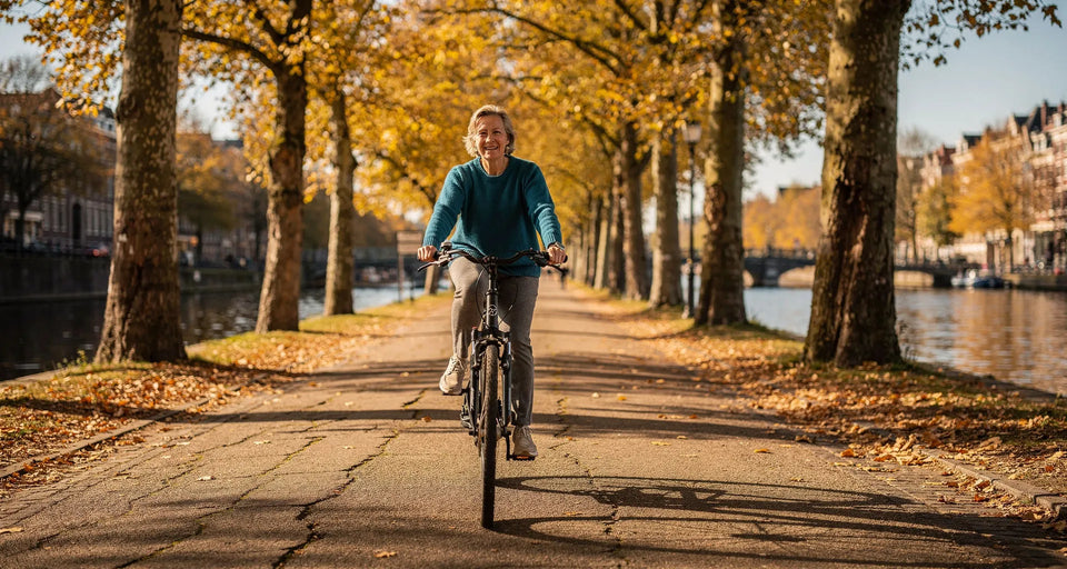 Radfahrerin in Petrol-Pullover auf einem Kanalweg mit Platanen im Herbst